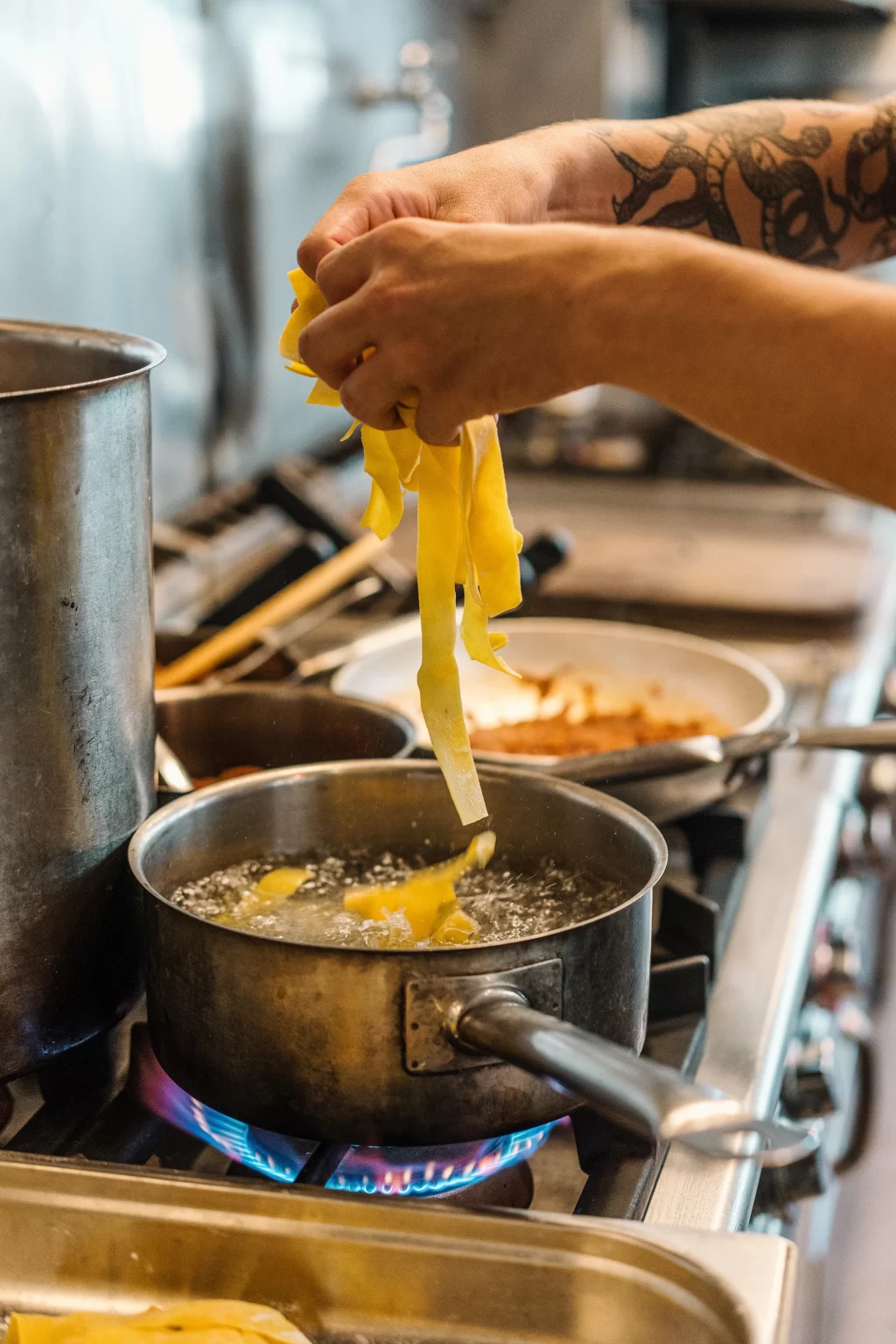 Pasta segar diaduk di wajan, langkah cara membuat fettuccine alfredo