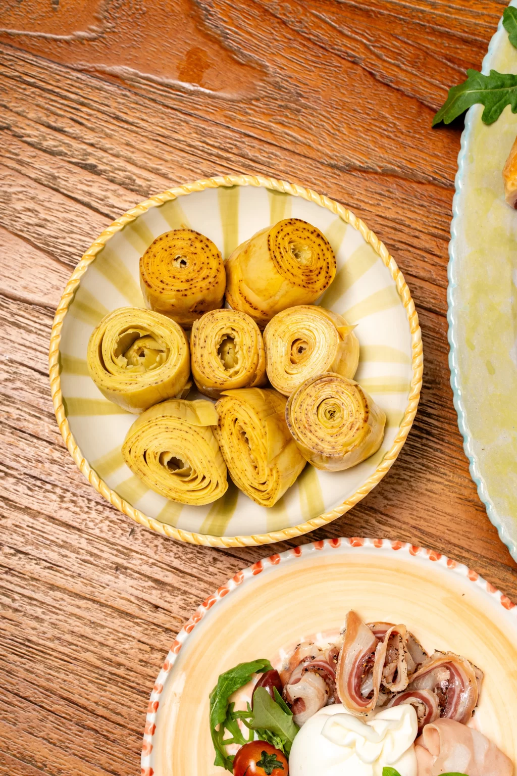 Fried artichokes and cold cuts served on a wooden table